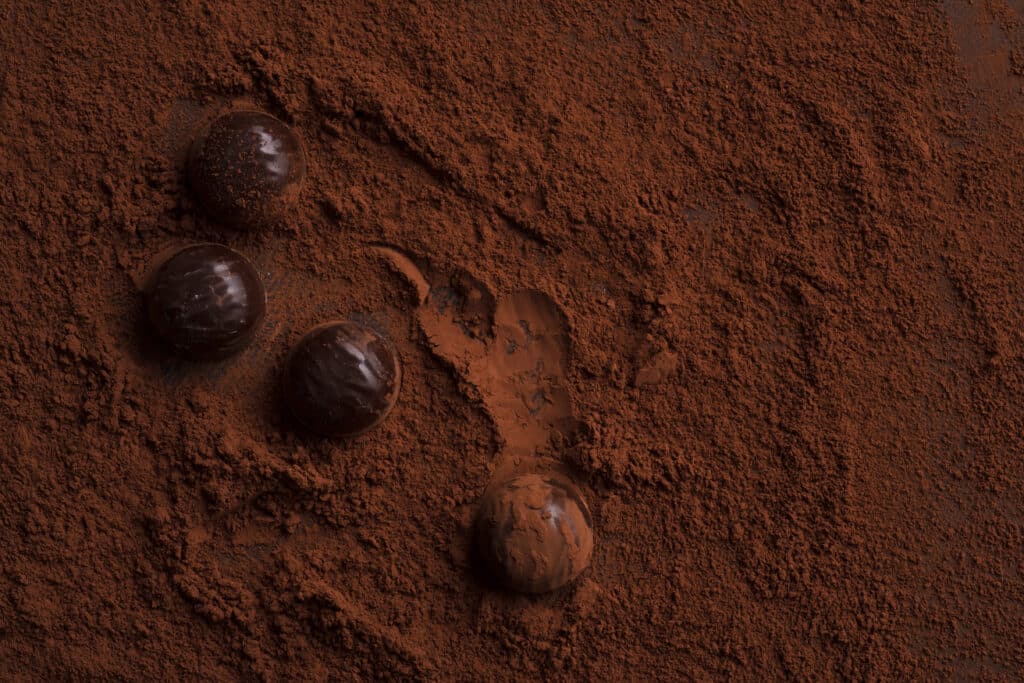 primer plano de caramelos de chocolate sobre chocolate en polvo